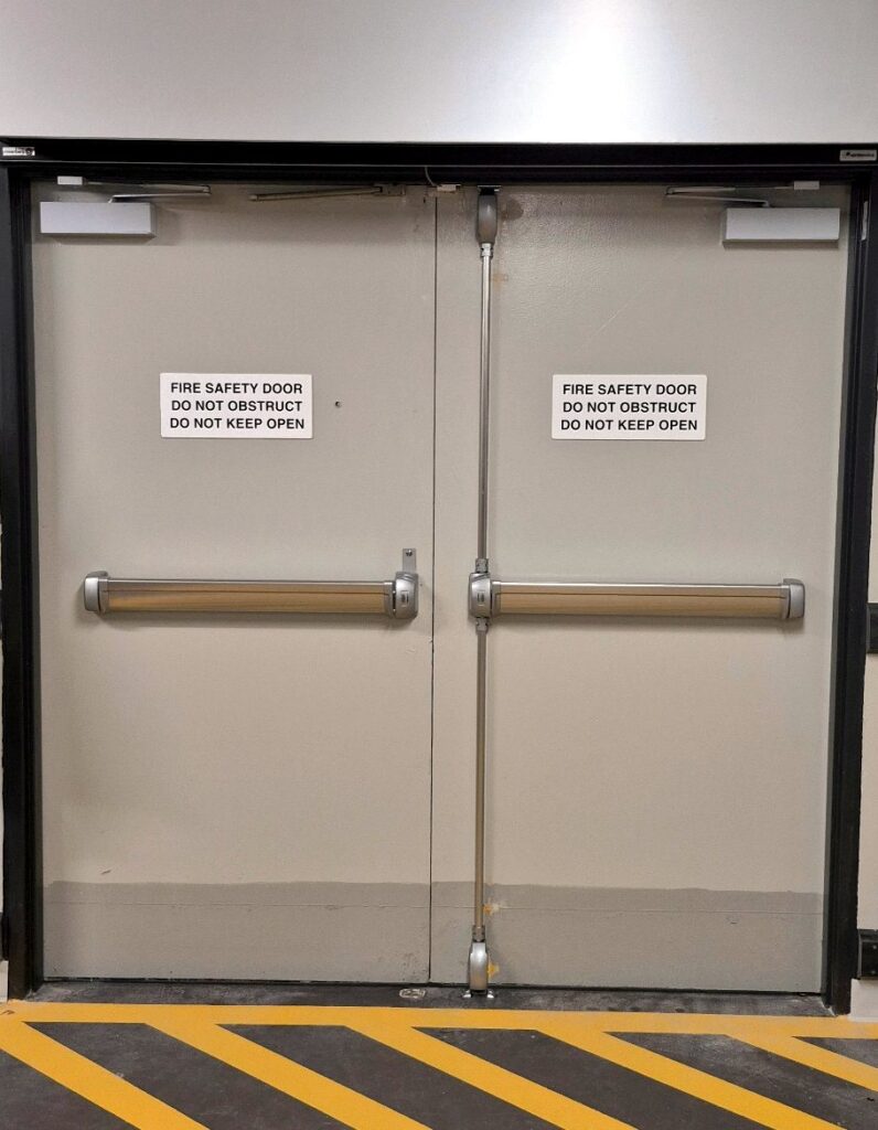Commercial exit doors fitted with panic-bar door hardware