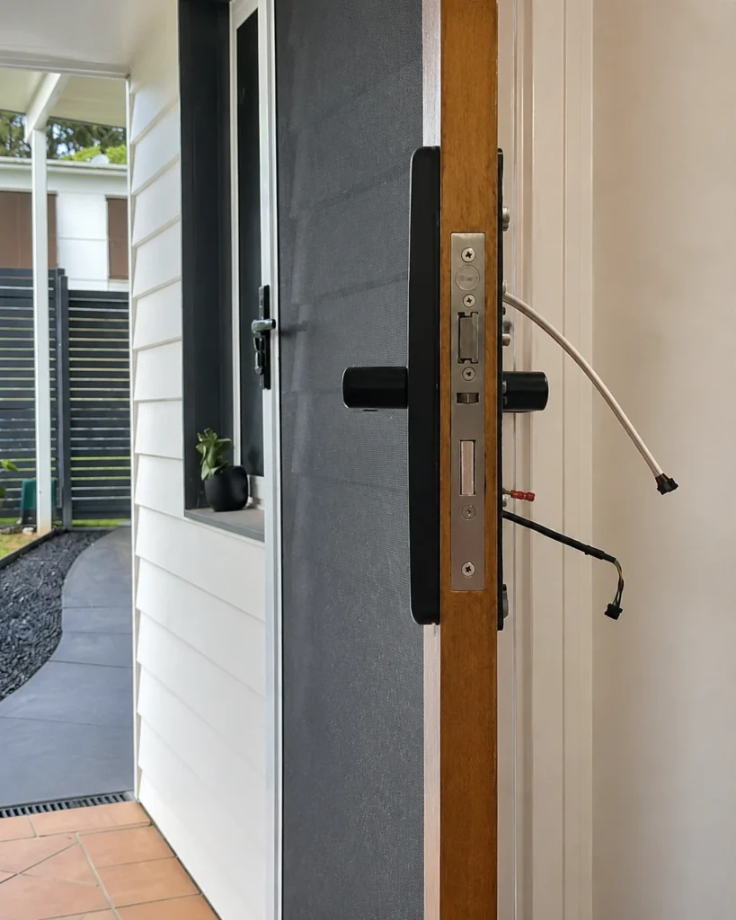 Smart lock wiring and mortice lock shown during installation on a timber door